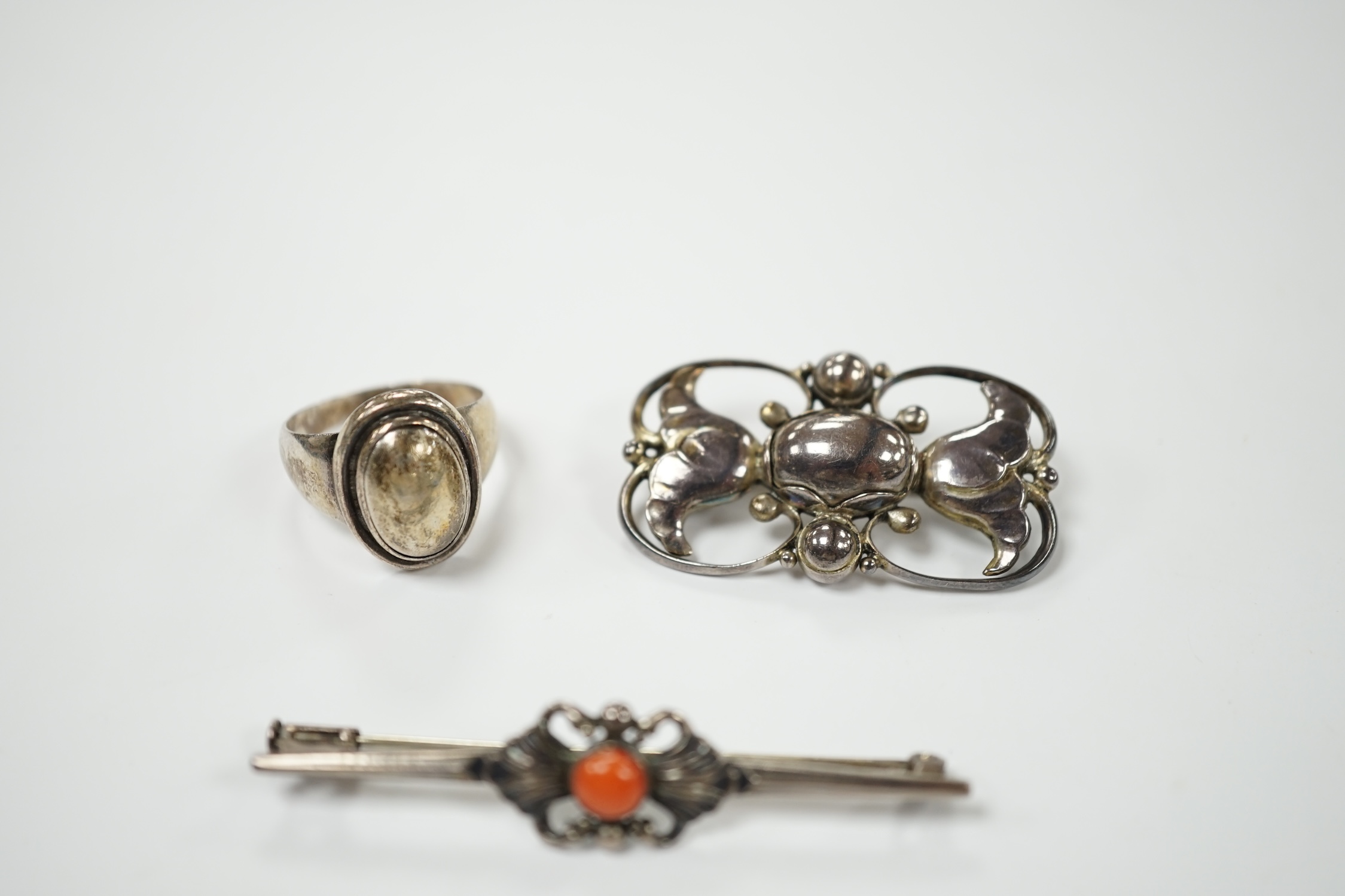 A Georg Jensen sterling and cabochon coral set bar brooch, design no. 214, 53mm, a similar Jensen brooch, design no. 236A, 37mm and a similar ring, design no. 46B, size M. Condition - fair to good